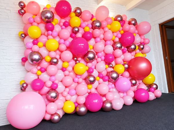 Parete di palloncini rosa, gialli e bordeaux