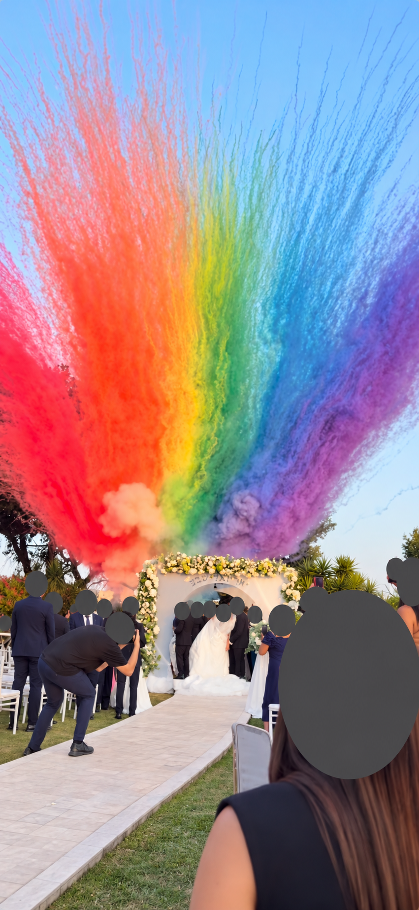 Effetto scenografico arcobaleno durante un evento, con le teste delle persone oscurate